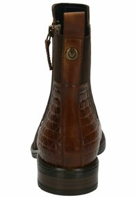 Stivale alla caviglia in pelle marrone con un motivo trapuntato e testurizzato, finitura liscia e una piccola zip con un accento metallico circolare sul retro.