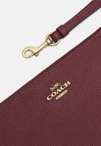 COACH POLISHED PEBBLE SMALL WRISTLET - Carteira de mão - wine