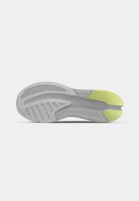 Semelle de chaussure de course avec un coloris gris et vert lime, présentant des rainures et des crêtes texturées pour la traction et la flexibilité.