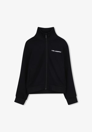 Veste noire zippée en tissu texturé. Elle présente un col montant, deux poches latérales, des poignets côtelés et un logo blanc sur la poitrine.