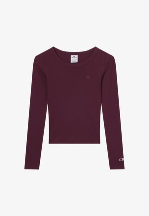 Ciemnofioletowa, długosleeve'owa, krótka bluzka z okrągłym dekoltem, z małym logo Champion na piersi i rękawie oraz metką rozmiaru wewnątrz kołnierza.