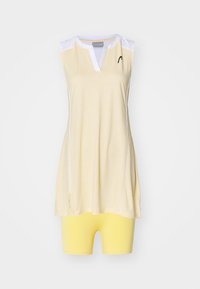 Tenue de sport sans manches comprenant un haut tunique jaune clair avec des accents blancs et des fentes latérales, associé à un short de vélo jaune assorti.