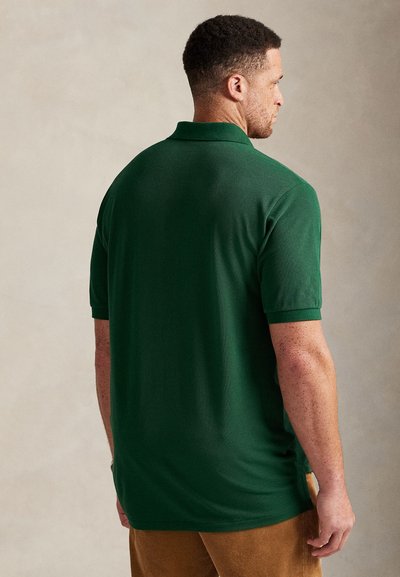 Πράσινο πόλο πουκάμισο με υφασμάτινη υφή, κοντά μανίκια και κλασικό γιακά, με άνετη εφαρμογή και πλαϊνές σχισμές για μεγαλύτερη άνεση.