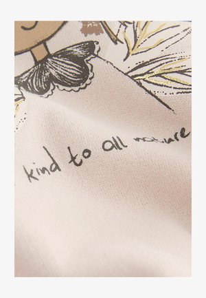 Bawełniana tkanina z ilustracją postaci z czarną kokardą. Na jasnoróżowym tle znajduje się czarny napis "bądź dobry dla całej przyrody".