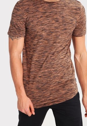 Braunes kurzärmliges T-Shirt mit einem strukturierten, gestreiften Muster, ausgestattet mit einem Rundhalsausschnitt und einem schlanken Schnitt. Getragen über dunklen Hosen.