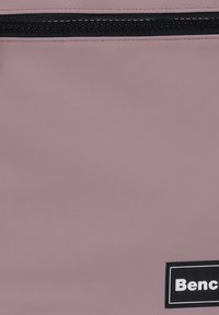 Paarse synthetische pouch met een getextureerd oppervlak, voorzien van een zwarte rits en een rechthoekig zwart merkje. Eenvoudig ontwerp met functionele elementen.