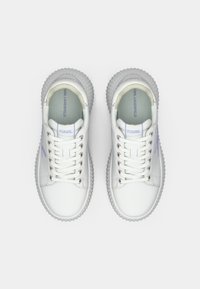 Λευκά δερμάτινα sneakers με στρογγυλεμένη μύτη, υφή στη σόλα από καουτσούκ και λιλά λεπτομέρειες. Διαθέτουν κορδόνια και λογότυπο "KARL LAGERFELD" στη γλώσσα.