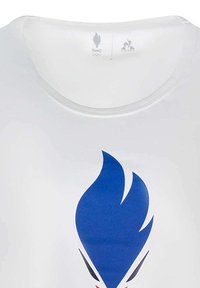 Chemise blanche à col rond ornée d'un grand graphisme de flamme bleue avec des accents rouges. Logos de la France et du Comité Olympique affichés au-dessus.