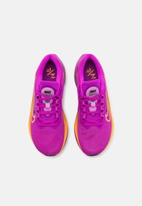 Fialové běžecké boty Nike s síťovaným svrškem, oranžovými akcenty a růžovými tkaničkami. Mají kulatou špičku a polstrovanou podrážku pro pohodlí.