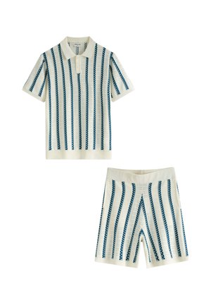 Ensemble polo à manches courtes en tricot blanc et short avec un motif à rayures verticales bleues sur fond blanc.