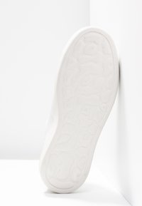 Biała podeszwa trampka z teksturowanym gumowym gripem, gładkimi brzegami i rozmiarem "37" wytłoczonym na spodzie. Prosty, minimalistyczny design.