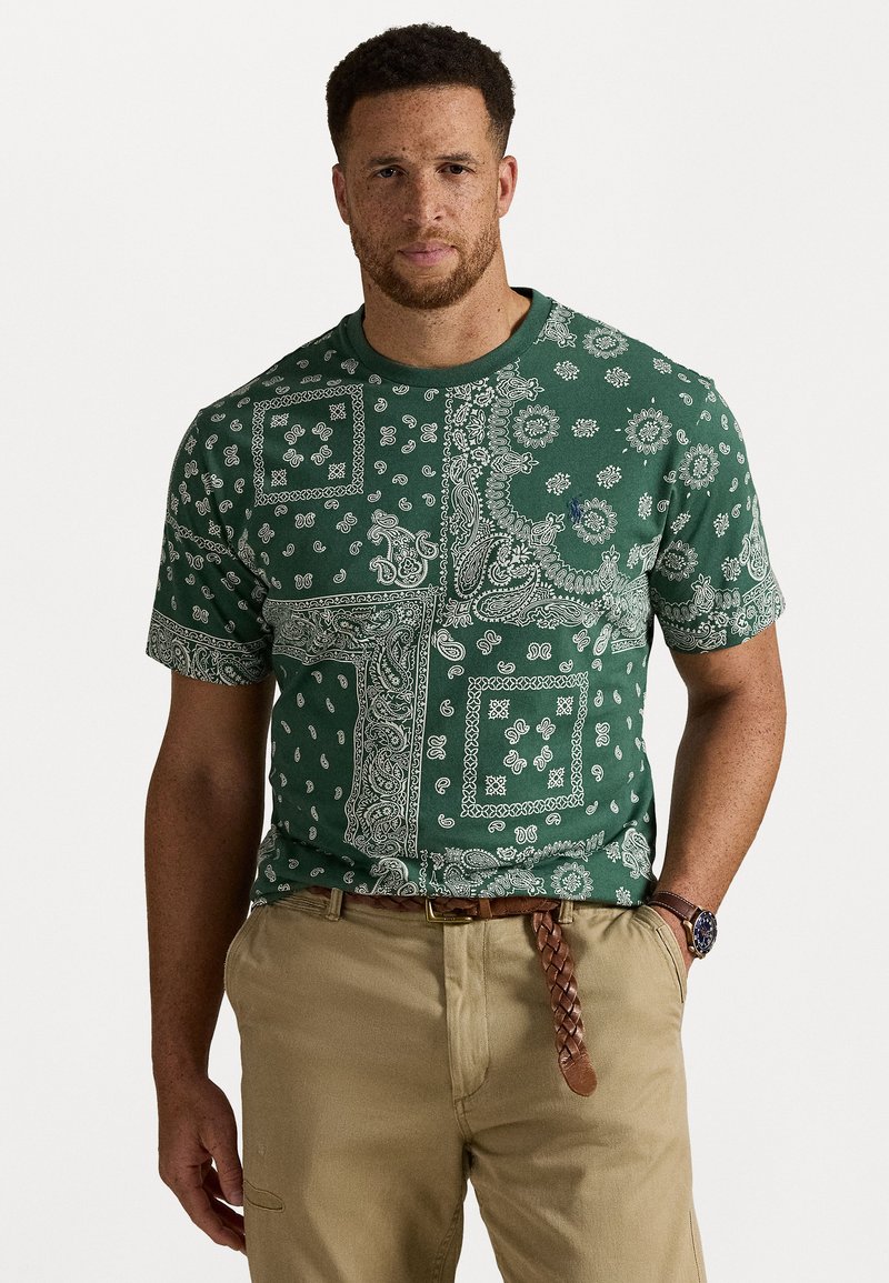 Grønn kortermet t-skjorte med hvit paisley-printdesign med varierte mønstre, rund hals og en avslappet passform.