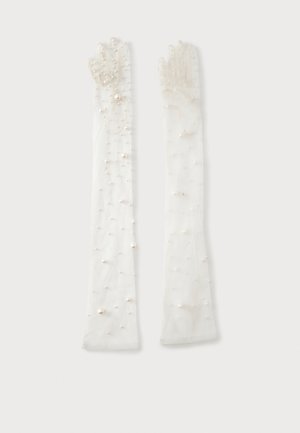 Longs gants blancs transparents décorés de perles petites et moyennes dispersées uniformément sur le tissu.