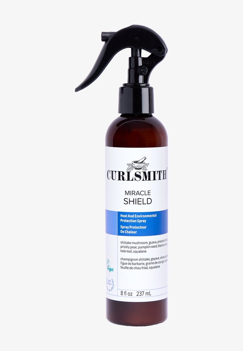 Curlsmith Miracle Shield sprayflaske, brunt glas med et sort trigger spraytop. Hvidt label med blå detaljer, tekst der beskriver produktets fordele.