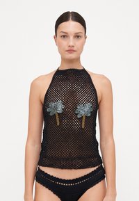 Top halter de ganchillo negro con diseño de malla abierta, que presenta dos aplicaciones decorativas de palmera en azul y plata en el pecho.