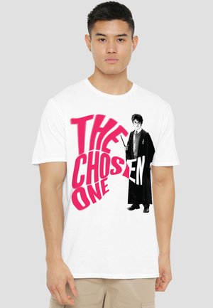Young man wearing white t-shirt with large red text "THE CHOSEN ONE" and a black-and-white wizard figure holding a wand.
