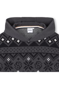 Camisola de malha cinza escura com capuz, apresentando um padrão geométrico em preto e branco. A etiqueta diz "BOSS." Textura suave, espessura média.