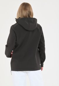 Veste noire imperméable avec capuche, caractéristiques d'une texture lisse, de manches longues et d'une poche zippée à l'ourlet latéral.