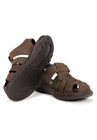 Sandalias de cuero marrón con diseño de punta abierta, correas entrelazadas y suela de goma texturizada para un mejor agarre.