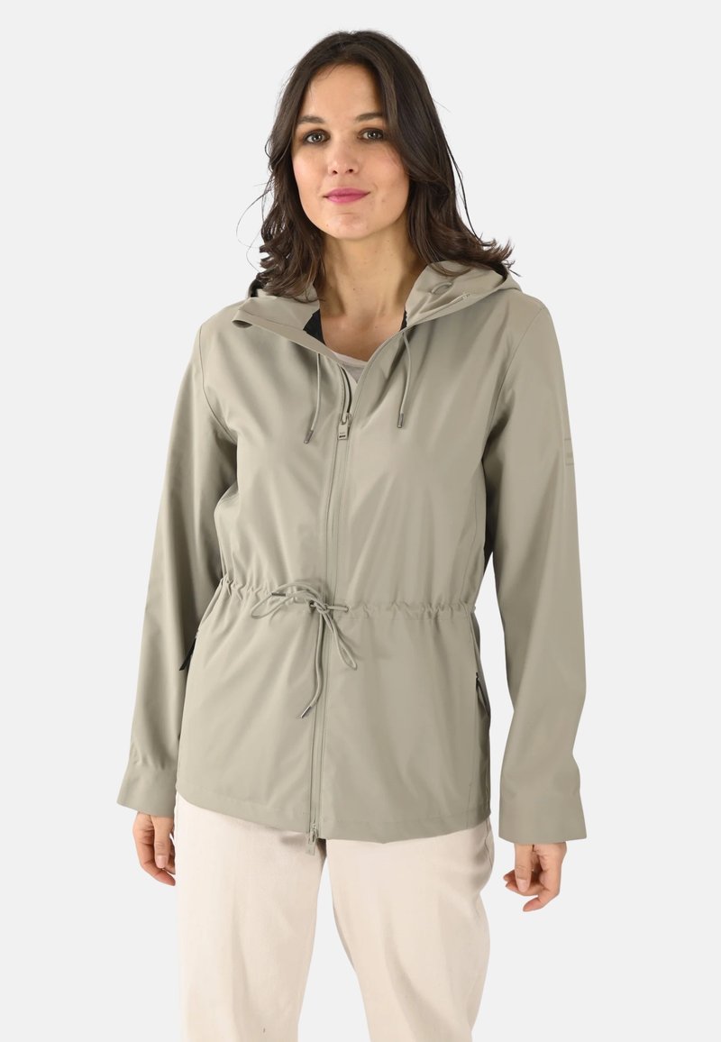 Chaqueta impermeable ligera de color beige con cremallera frontal, capucha ajustable, cinturilla elástica y bolsillos laterales. Textura suave con un diseño entallado.