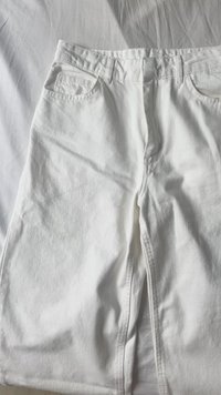 Weiße Jeans mit fünftaschen Design, sichtbarer Textur und geradem Beinschnitt. Der Stoff zeigt subtile Falten und Nähdetails.