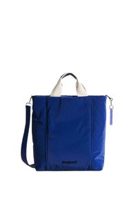 Marinblå tote-väska med krämfärgade handtag och axelrem. Har en slät, stilren yta och en rektangulär form. Innehåller en etikett.