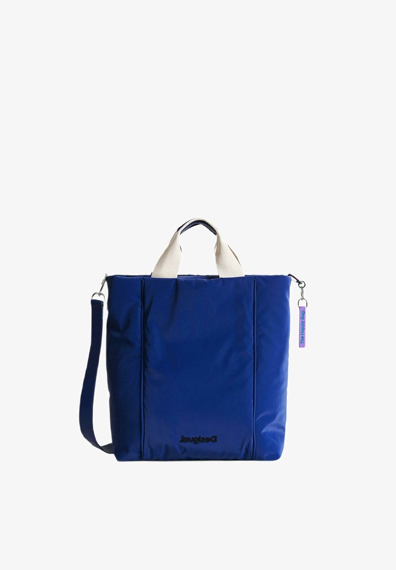 Marinblå tote-väska med krämfärgade handtag och axelrem. Har en slät, stilren yta och en rektangulär form. Innehåller en etikett.