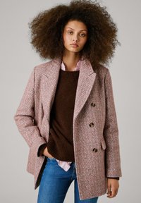 Manteau en mélange de laine rose et marron à motif chevron, avec fermeture à double boutonnage, larges revers et poches latérales.