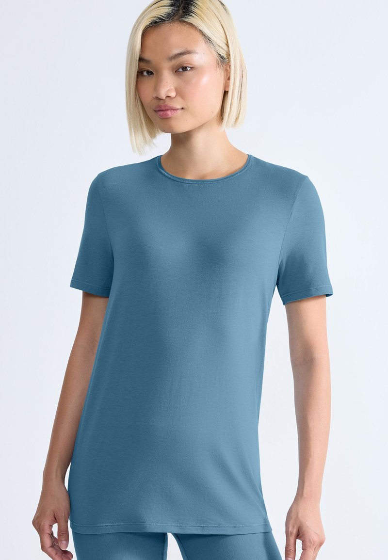 Korte ærmer blå t-shirt med rund halsudskæring, glat tekstur og afslappet pasform. Stoffet virker blødt og let.