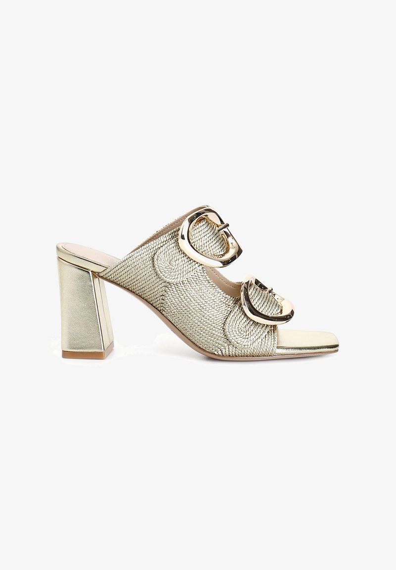 Mule-uri cu toc aurii, cu textură împletită, vârful deschis și catarame circulare mari. Toc pătrat gros pentru stabilitate.