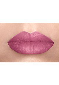 Rossetto opaco rosa applicato su labbra carnose con una superficie strutturata, che mostra una finitura liscia e una distribuzione uniforme del colore.