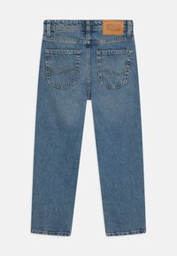 Jeans de mezclilla azul claro con un corte recto, que cuentan con dos bolsillos traseros, costuras visibles y un parche de cuero con la marca en la cintura.