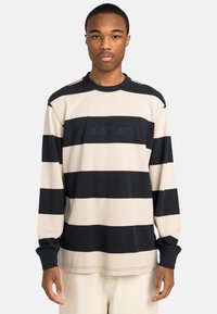 Langsleeve gestreepte shirt met afwisselend marineblauwe en beige strepen, een ronde hals en geborduurd merkwapen op de borst. Gemaakt van katoen.