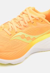 Chaussure de course en mesh orange vif avec des accents jaune clair, dotée d'une semelle rembourrée et d'un design texturé pour la respirabilité.