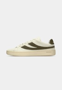 Sneaker od off-white kože s bež potplatom i tamnozelenim nubuk valovitim dizajnom sa strane, prikazan sa vanjske strane.