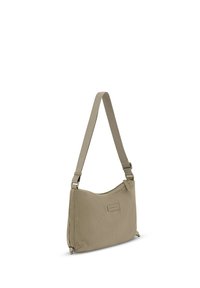 Bolso de hombro de tela beige acanalada con correa ajustable y pequeño etiqueta rectangular de la marca en el frente, cierre con cremallera en la parte superior.
