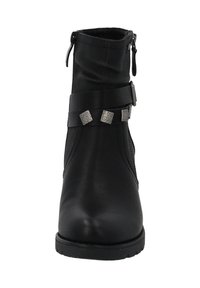 Botín negro hecho de cuero sintético, con una correa de cuero decorativa y acentos metálicos, textura suave y punta redonda.
