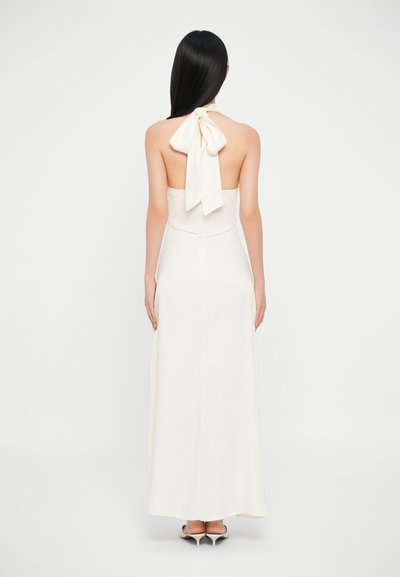 Rochie maxi de culoare crem, cu gât halter și fundă la spate. Textură netedă, corset ajustat și fustă fluidă.