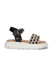 Zwarte en beige geweven sandalen met een verstelbare enkelband, voorzien van een stevige witte zool en een gestructureerd bovenmateriaal.