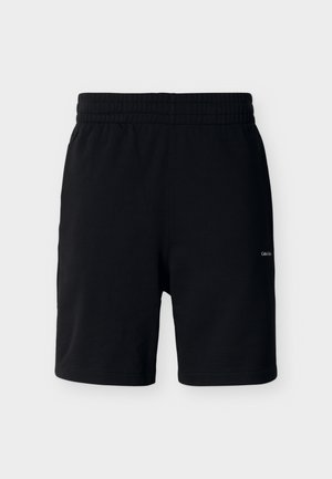 Μαύρα σορτς μέχρι το μέσο του μηρού με ελαστική μέση, κατασκευασμένα από απαλό ύφασμα, με μικρό λευκό λογότυπο Calvin Klein στο δεξί πόδι.