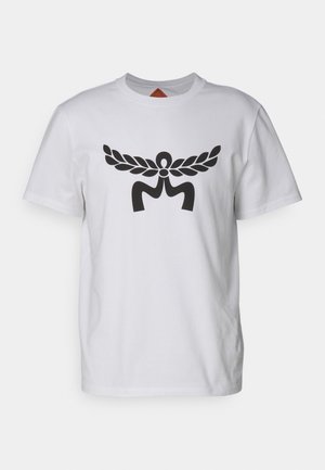 T-shirt bianco in cotone con un grande motivo grafico nero al centro che assomiglia a delle ali e a una lettera "M" stilizzata. Maniche corte, collo rotondo.
