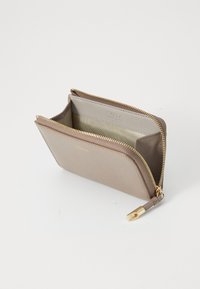 Ritstas in lichtbeige leer met een textuur, met een gouden rits en interne compartimenten voor organisatie.
