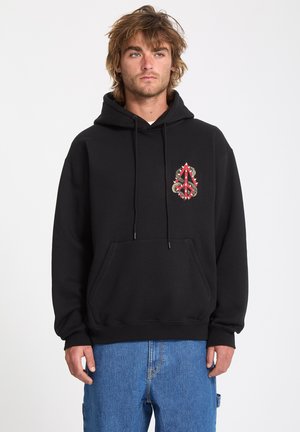 Hoodie noir avec une poche avant et des cordons de serrage. Présente un emblème rouge et argent avec des motifs complexes sur la zone gauche de la poitrine.