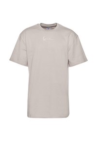 Beige cotton t-shirt with short sleeves, crew neck, and a white script logo printed on the front. Smooth texture and casual fit.