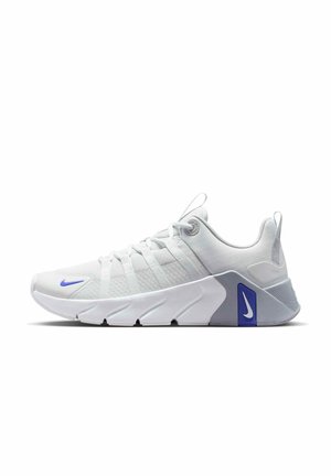 Witte atletische sneaker met blauwe Nike Swoosh-logo's, mesh bovenwerk en dikke gesegmenteerde zool ontworpen voor ondersteuning en comfort.