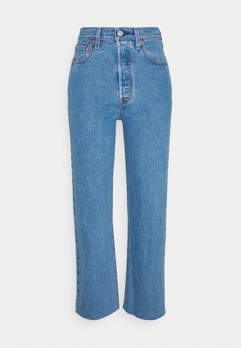 Jean taille haute bleu clair avec une coupe droite, présentant des coutures visibles et cinq poches. Confectionné en denim avec une finition légèrement texturée.