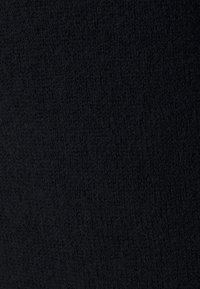 Schwarzer strukturierter Stoff mit weicher, gestrickter Optik; weist eine einheitliche, leicht flauschige Oberfläche auf, ohne ausgeprägte Muster oder Akzente.