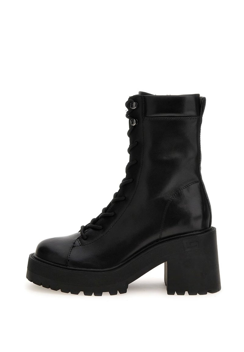 Bota de combate de cuero negro hasta la mitad de la pantorrilla con suela de plataforma gruesa, tacón bloque robusto, parte delantera con cordones y ojales de metal.