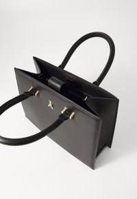 Black leather handbag with two handles, gold hardware accents, rectangular shape, and an open top design, showcasing an interior pocket.
