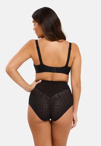 Soutien-gorge noir avec bretelles ajustables et fermeture par crochet, associé à une culotte noire taille haute avec un dos en dentelle florale transparente.